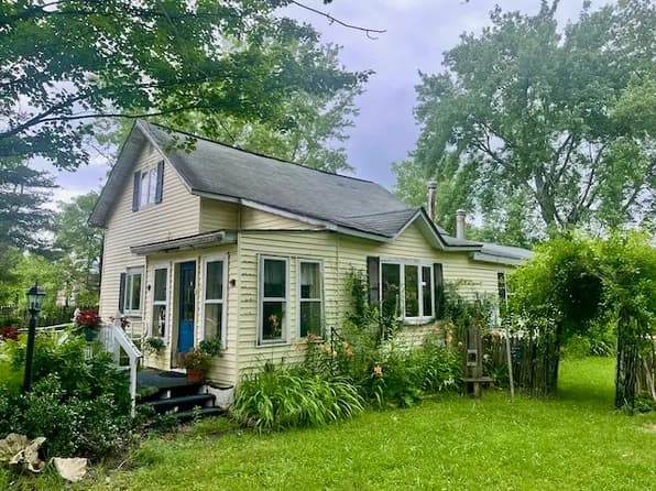 Older two-storey farmhouse with mature plantings