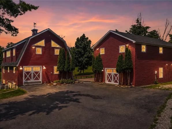 Restored red barns at dusk on a rural Central New York property